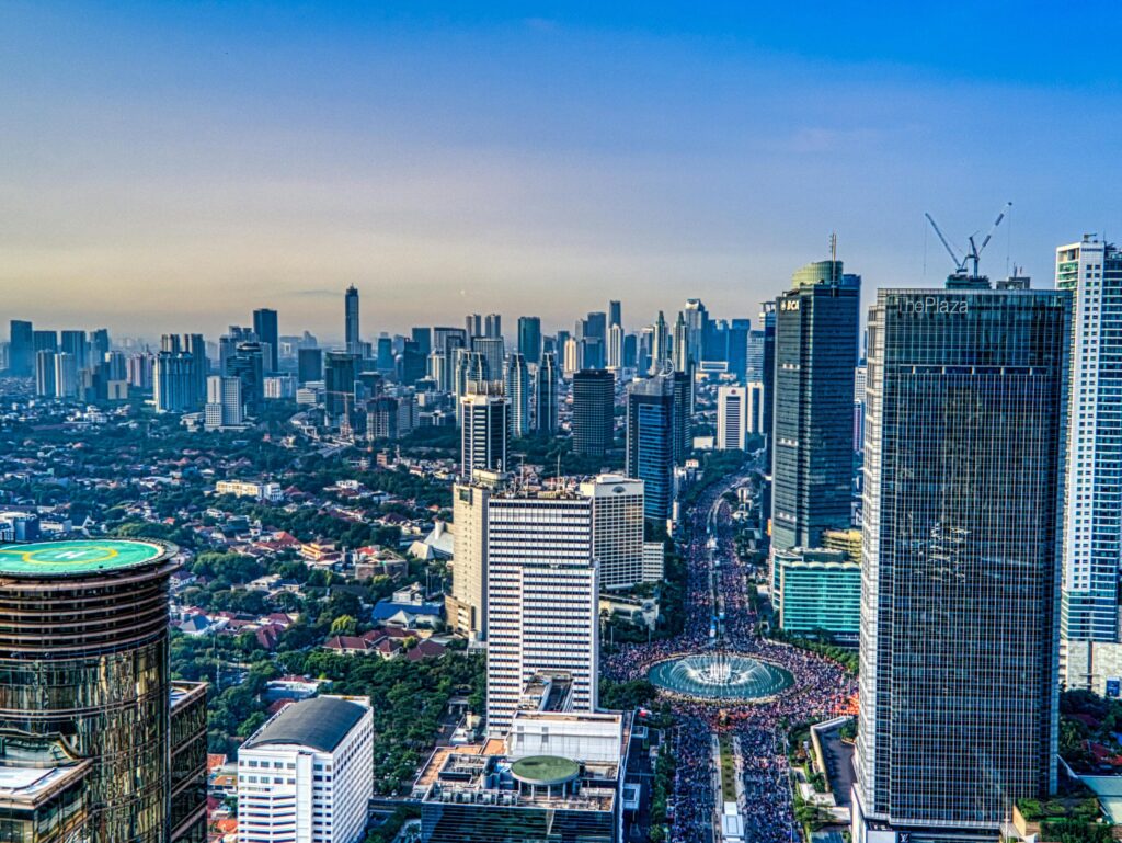 A breathtaking aerial view of Jakarta's urban skyline during the day, showcasing skyscrapers and city life.
